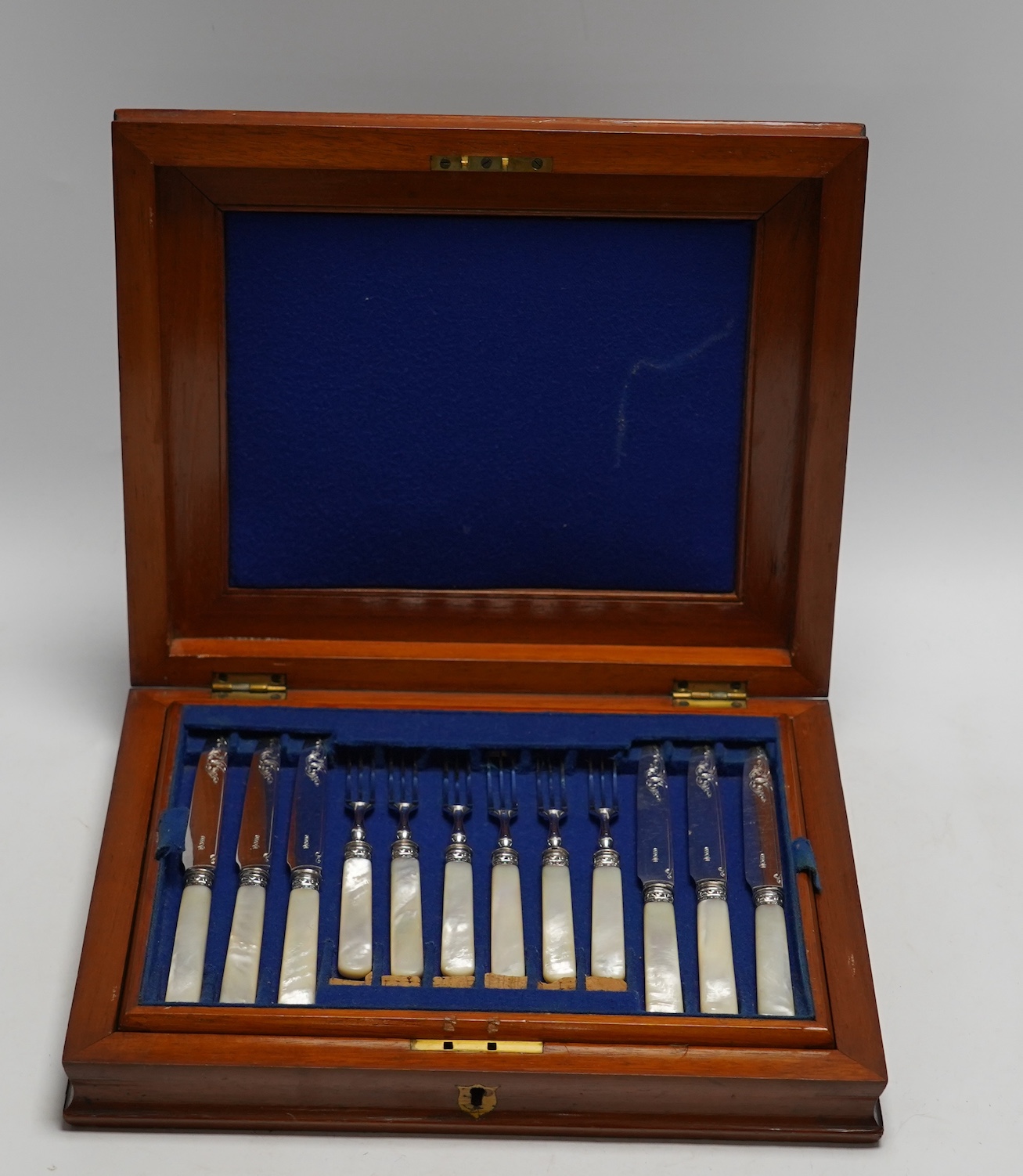 Two cased sets of silver plated dessert eaters, one with mother of pearl handles, largest 30cm wide, 27cm deep. Condition - cutlery good, largest case scratched